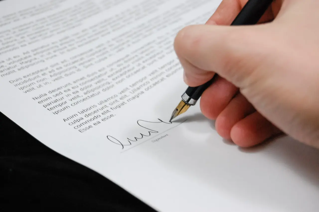 a hand signing a document