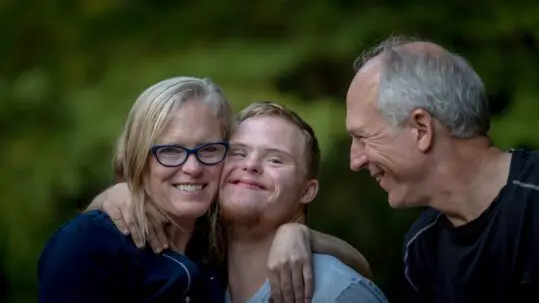 family hugging special needs son