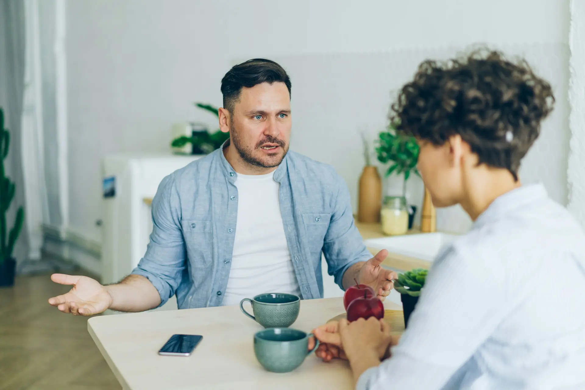 a mana and woman arguing at table