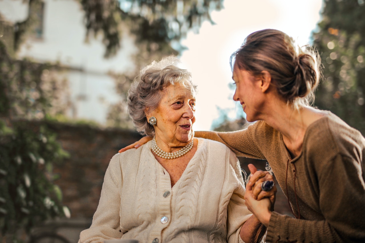 power of attorney - older woman holding hand of younger woman
