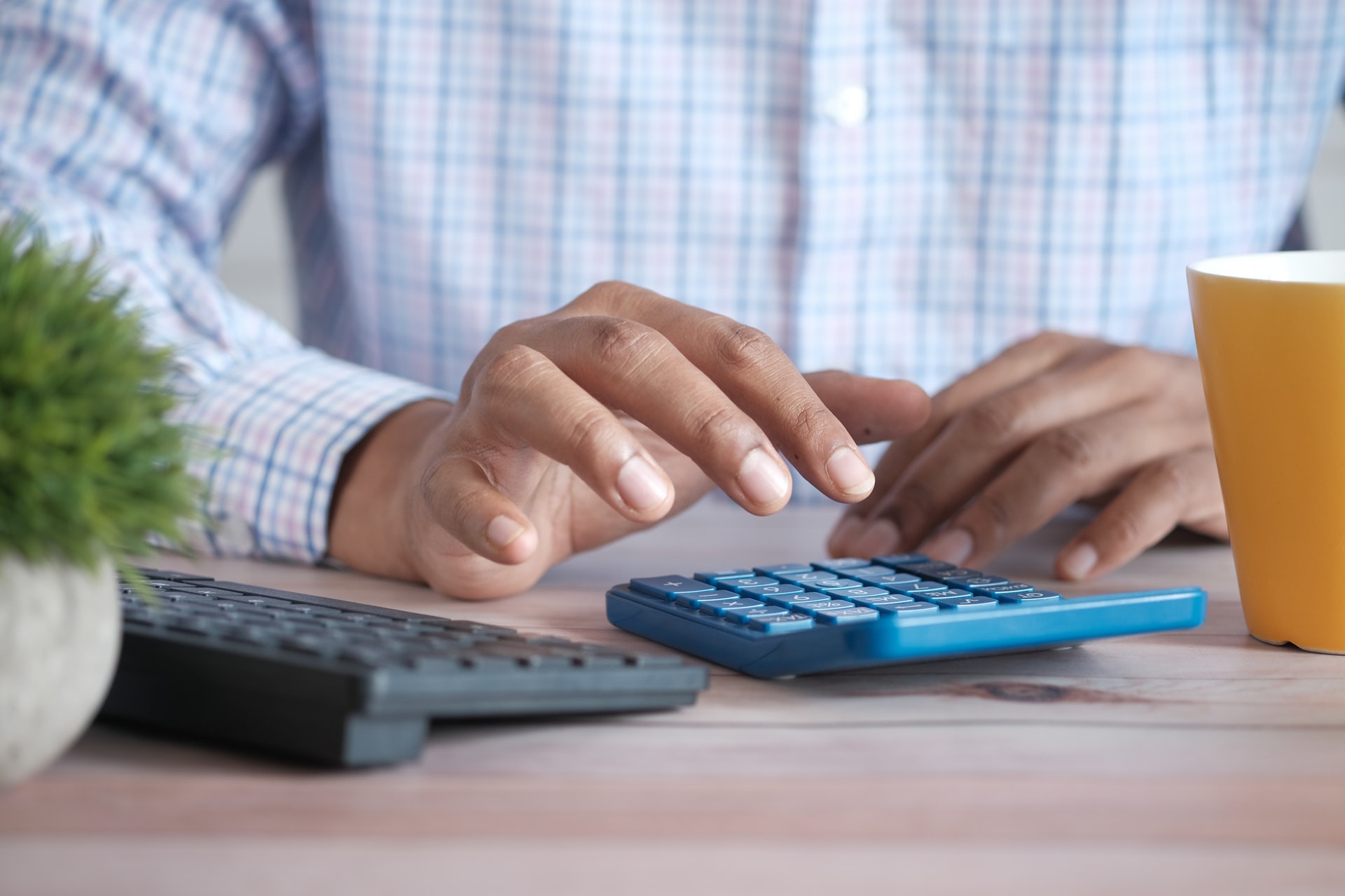 saving for retirement - human hand using calculator on a desk