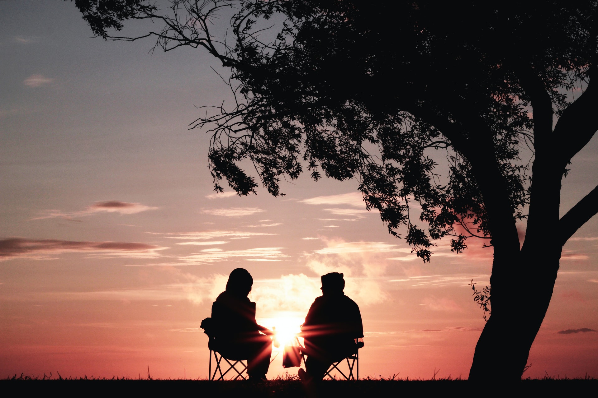 last will vs living will -- two people sitting in chairs watching the sun set