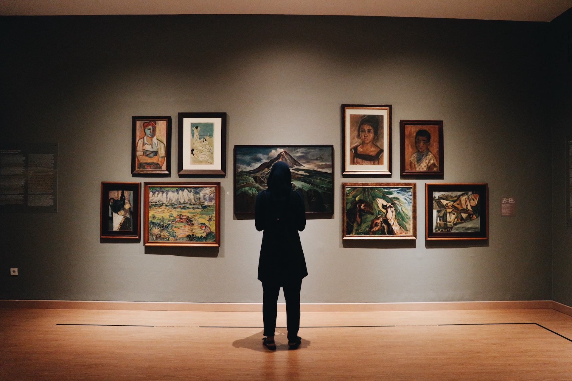 woman standing in front of museum paintings