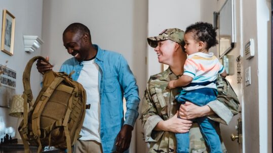 military couple holding child and laughing