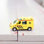 a bright yellow toy ambulance sitting on gray counter